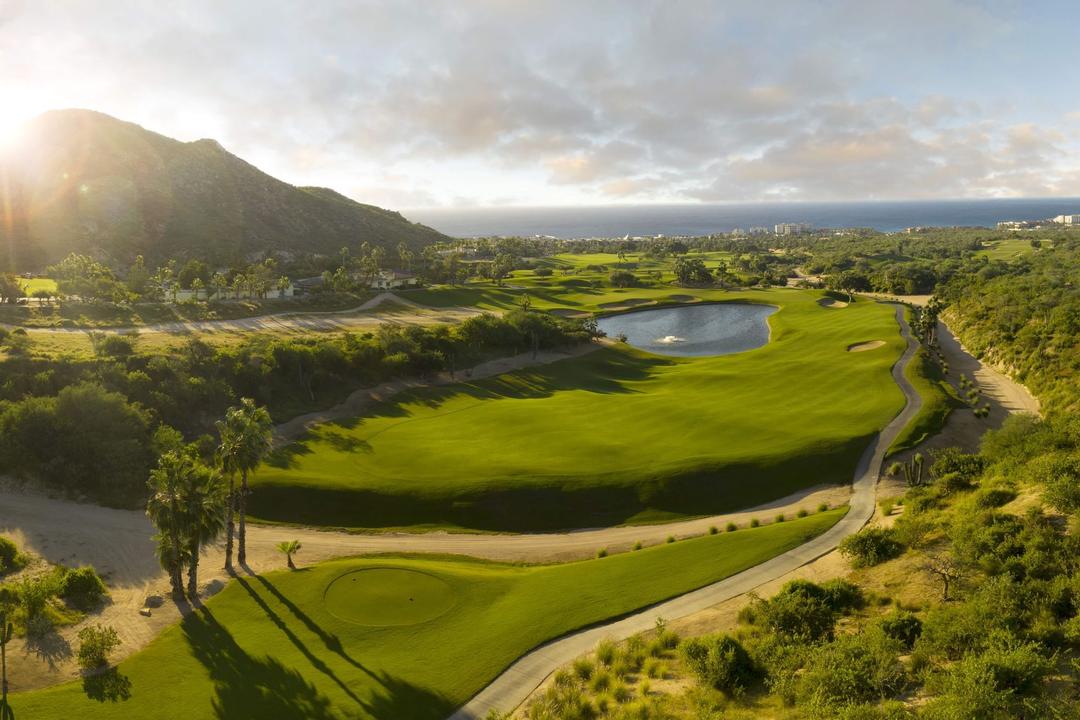Dramatic sunset aerial view of Cabo Real golf course with water features