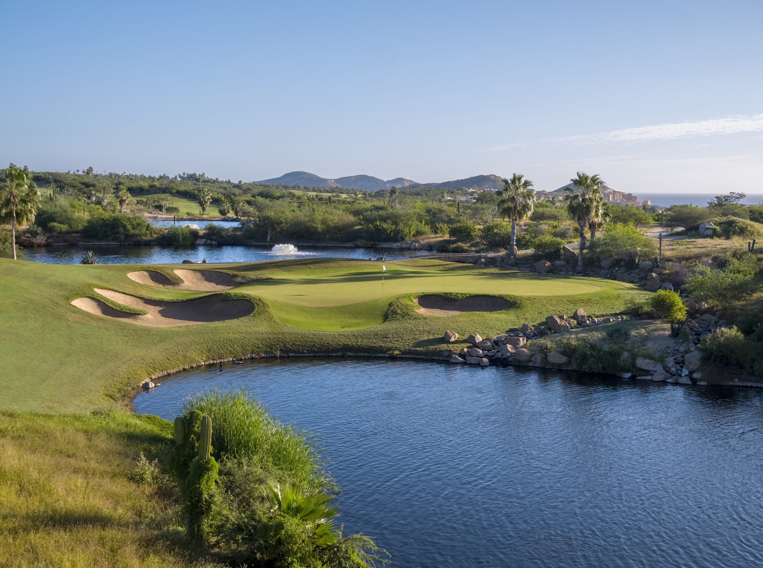 Cabo del Sol signature water hole with multiple bunkers and mountain backdrop
