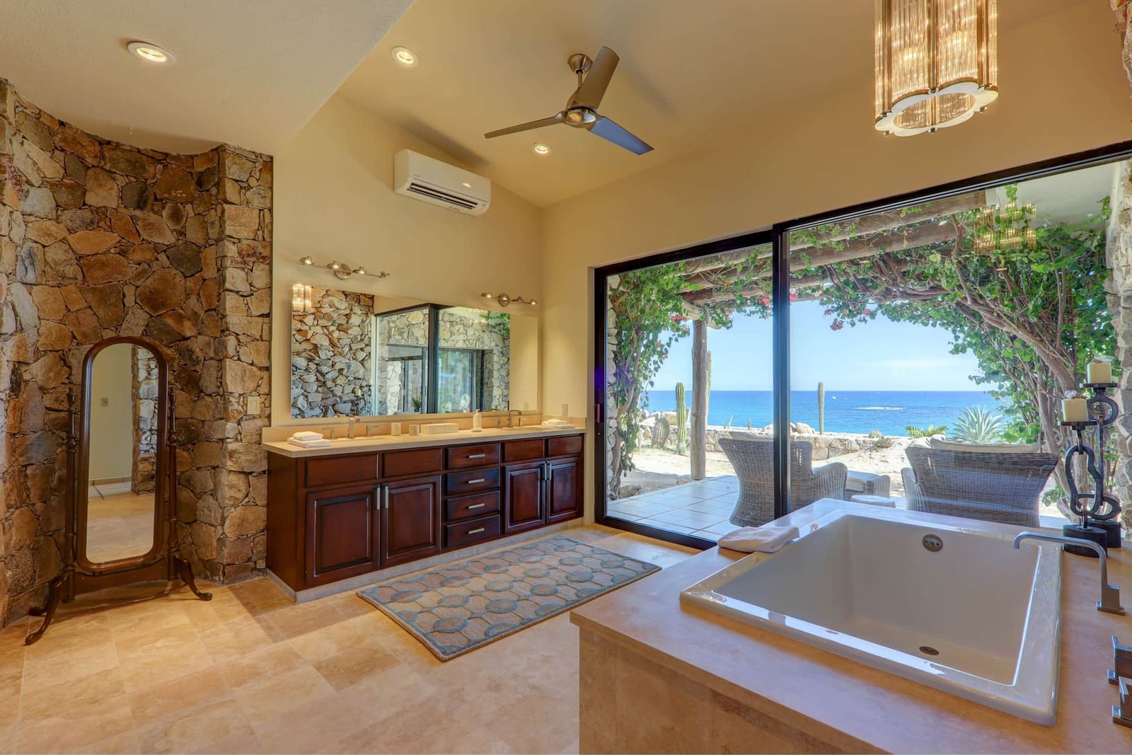 Luxury master bathroom with natural stone walls and ocean views