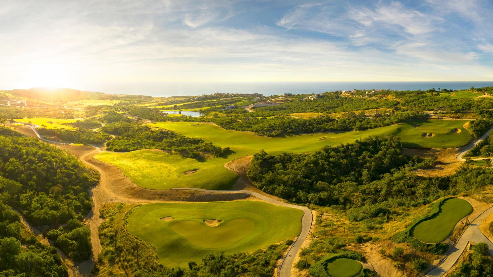Puerto Los Cabos aerial view with golden sunset lighting and multiple golf holes