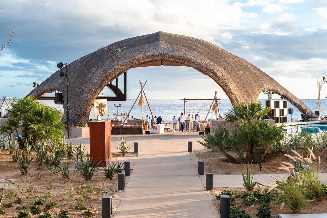 Cultural event space under dramatic curved palapa structure showcasing Q Life cultural experiences and community gatherings